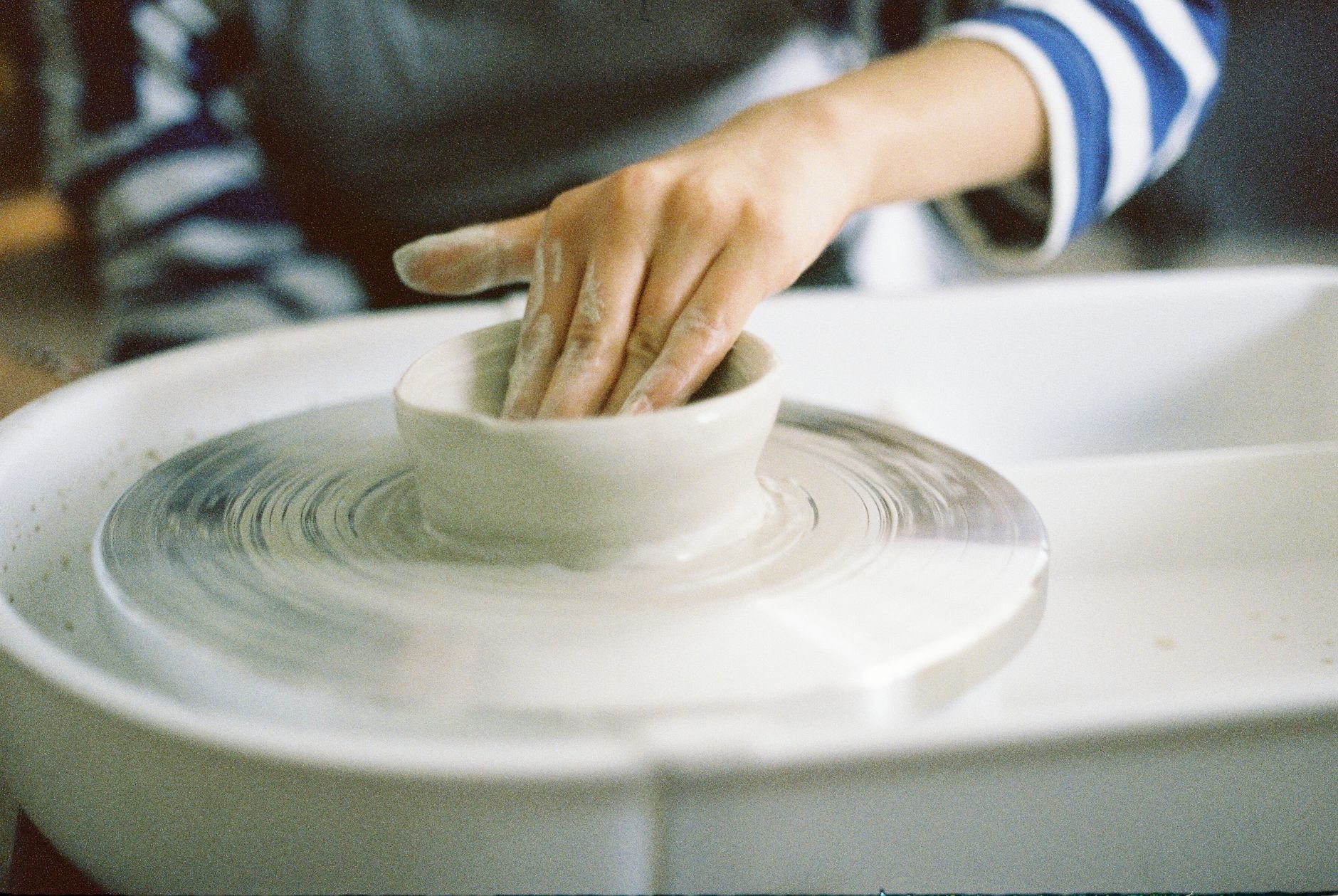 Close-up of hands shaping clay on a pottery wheel